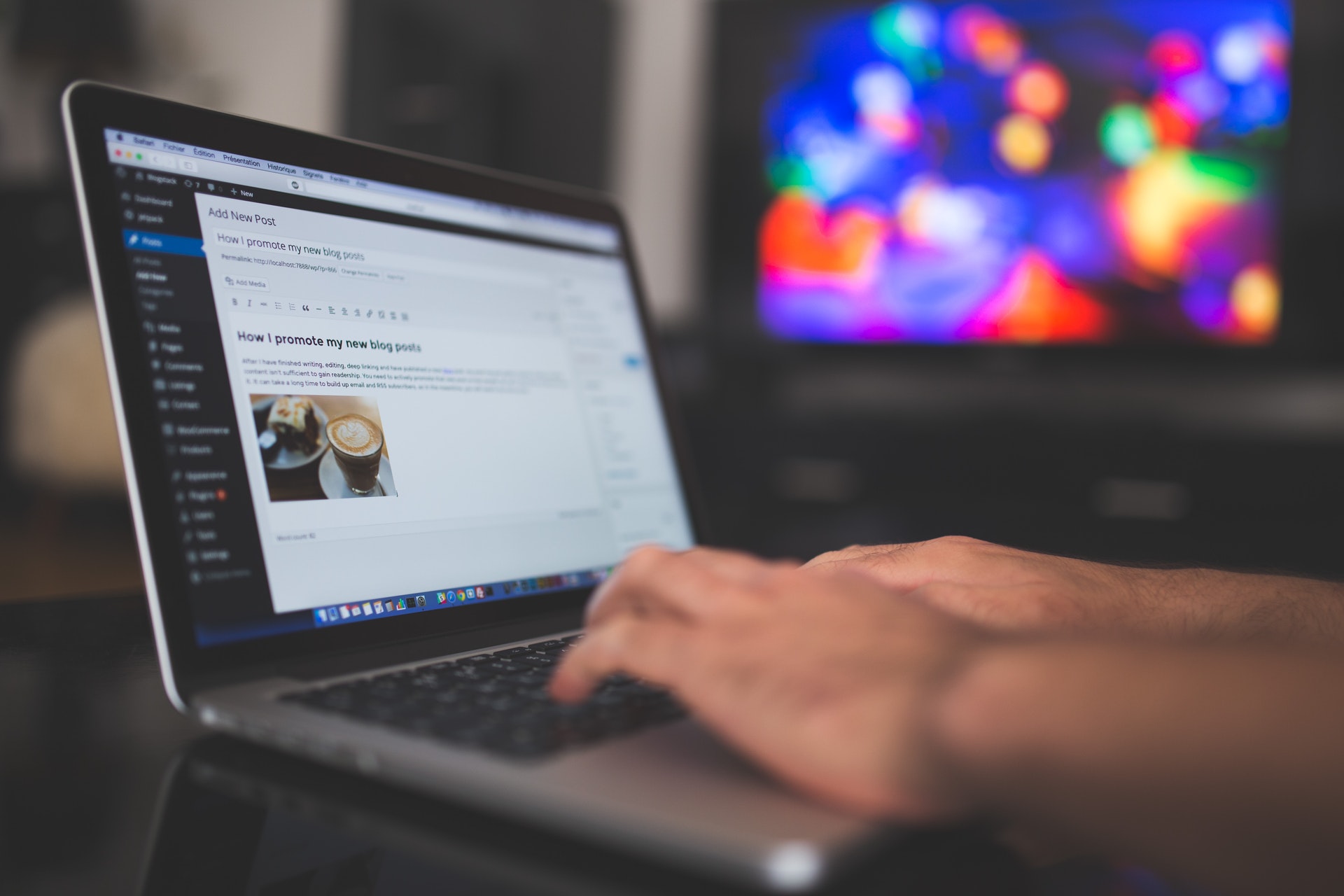 Person typing a blogpost on a silver laptop